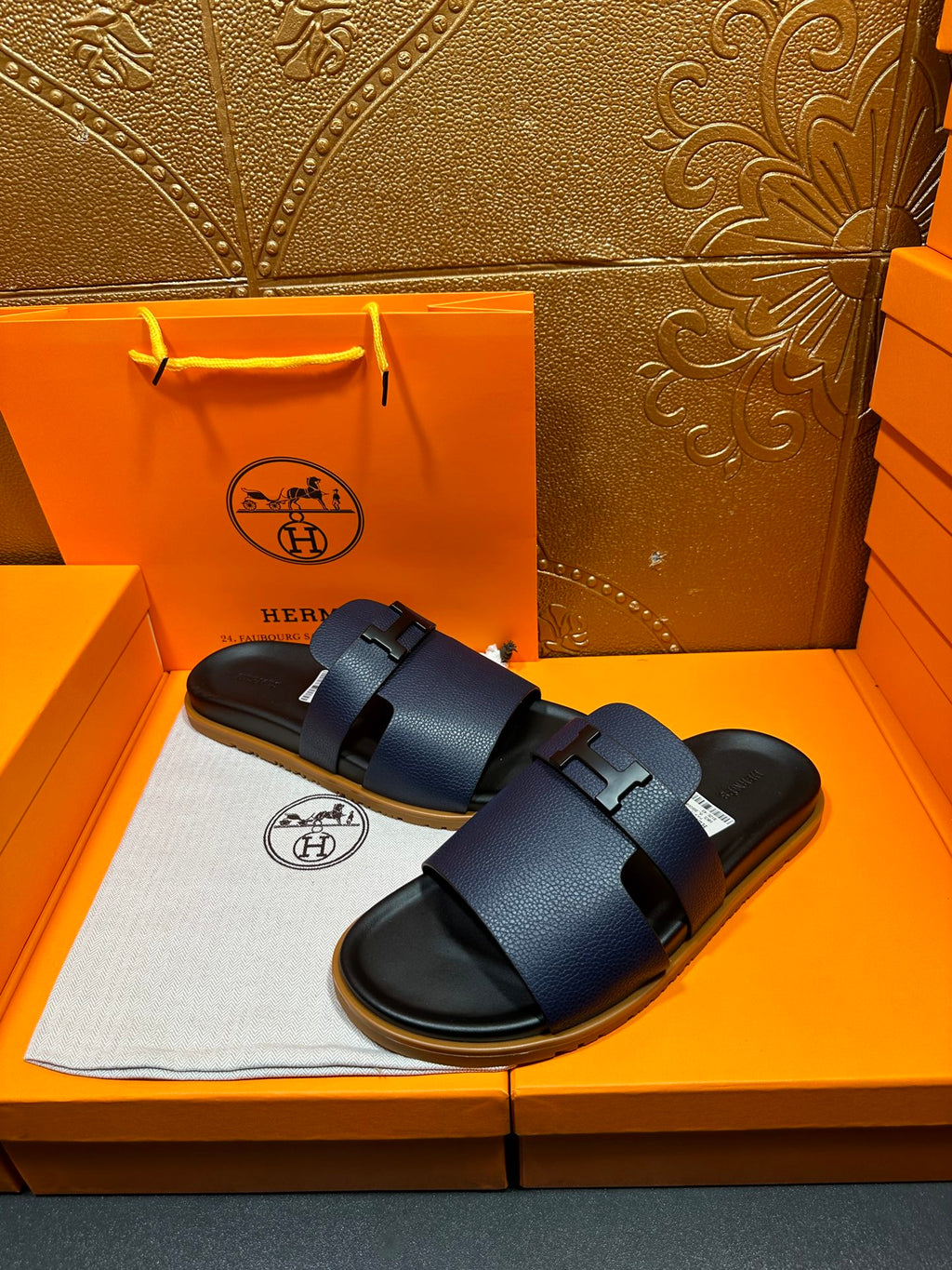 Hermes dark blue slide sandals with two wide buckle straps, front view