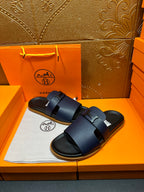 Hermes dark blue slide sandals with two wide buckle straps, front view