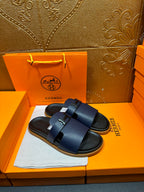 Hermes dark blue slide sandals with two wide buckled straps, side view