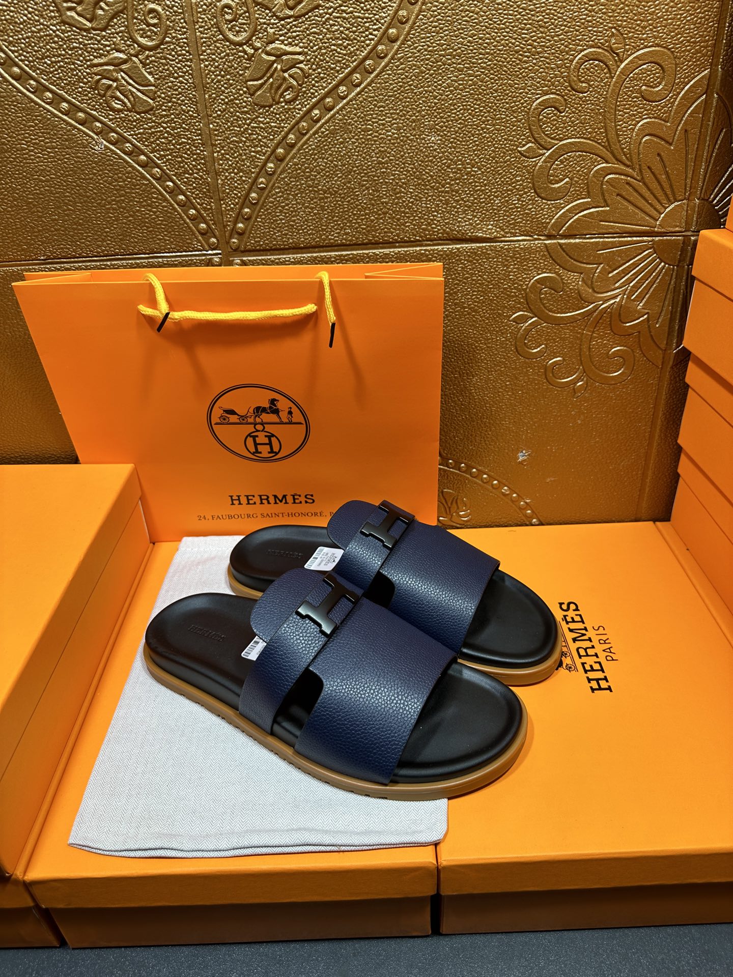 Hermes dark blue slide sandals with two wide buckled straps, side view