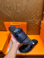 Hermes dark blue slide sandals held up, with two wide buckle straps