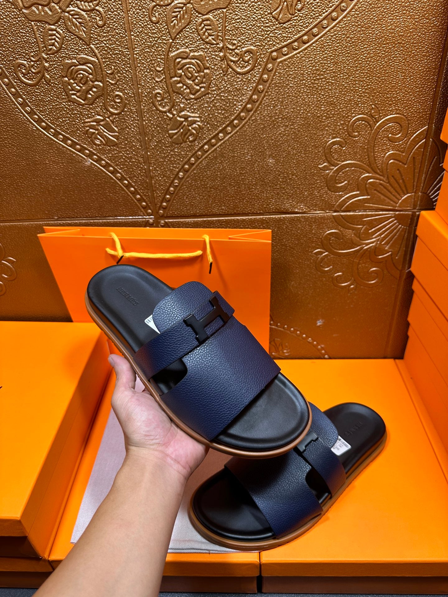 Hermes dark blue slide sandals held up, with two wide buckle straps
