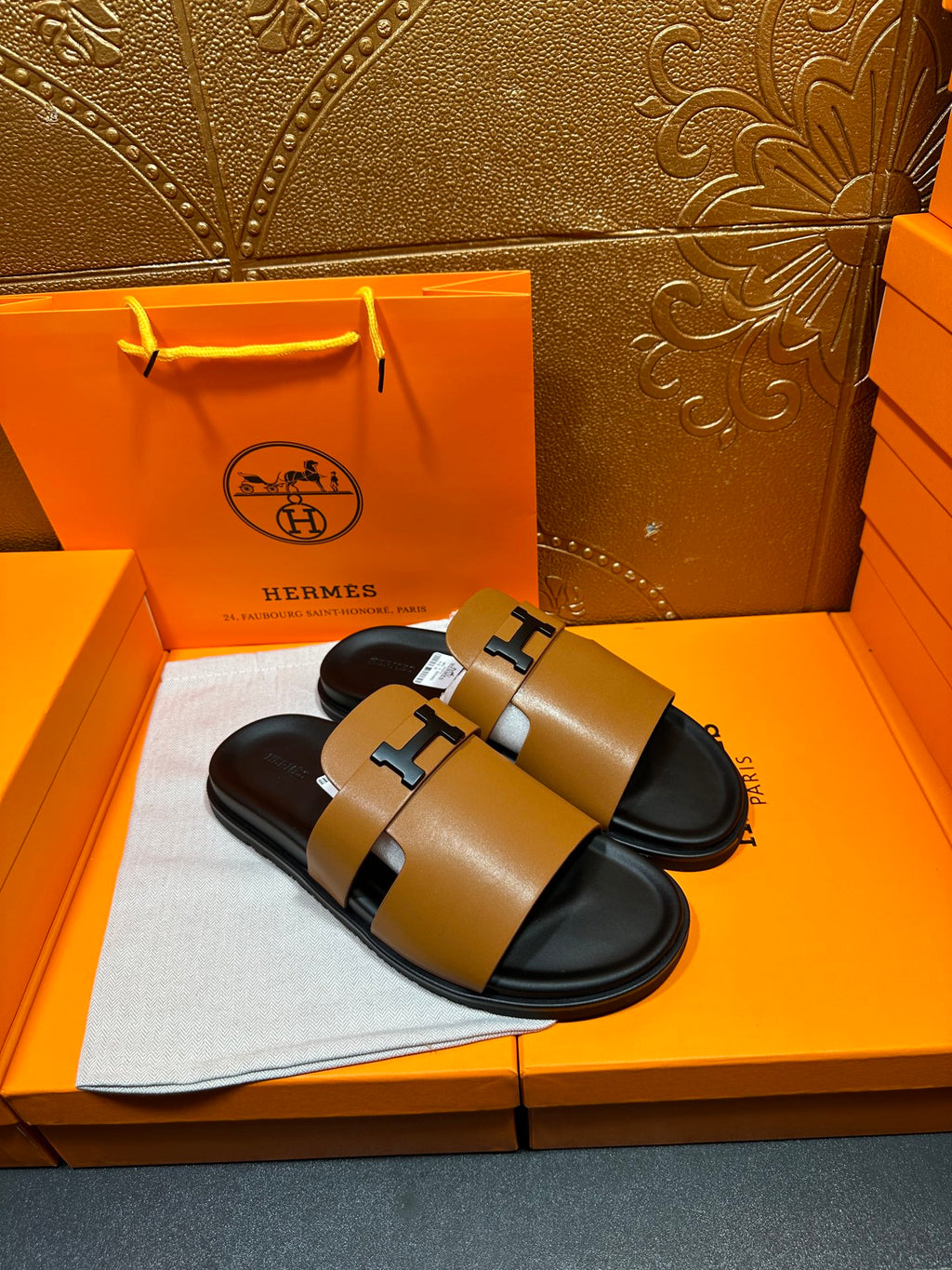 Hermes tan leather slide sandals with black footbed and dark H buckle detail