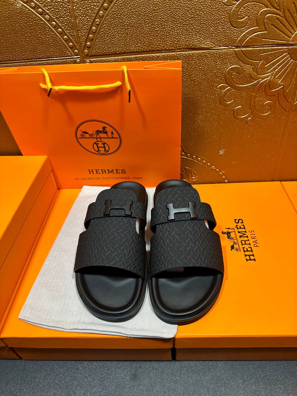 Black textured slide sandals with single H buckle strap