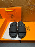 Black textured slide sandals with single H buckle strap