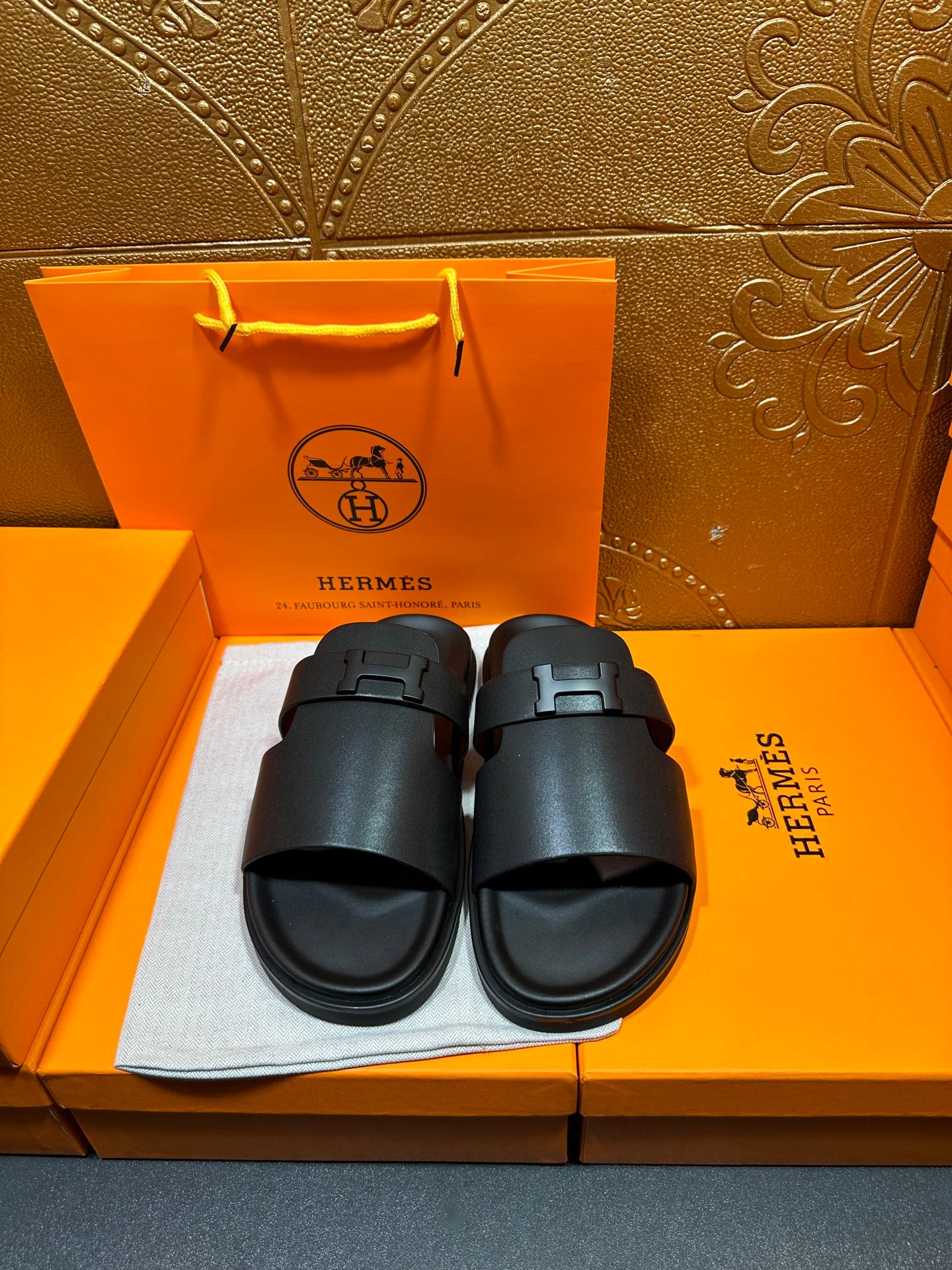 Black leather slide sandals with wide strap and adjustable buckle, cushioned footbed