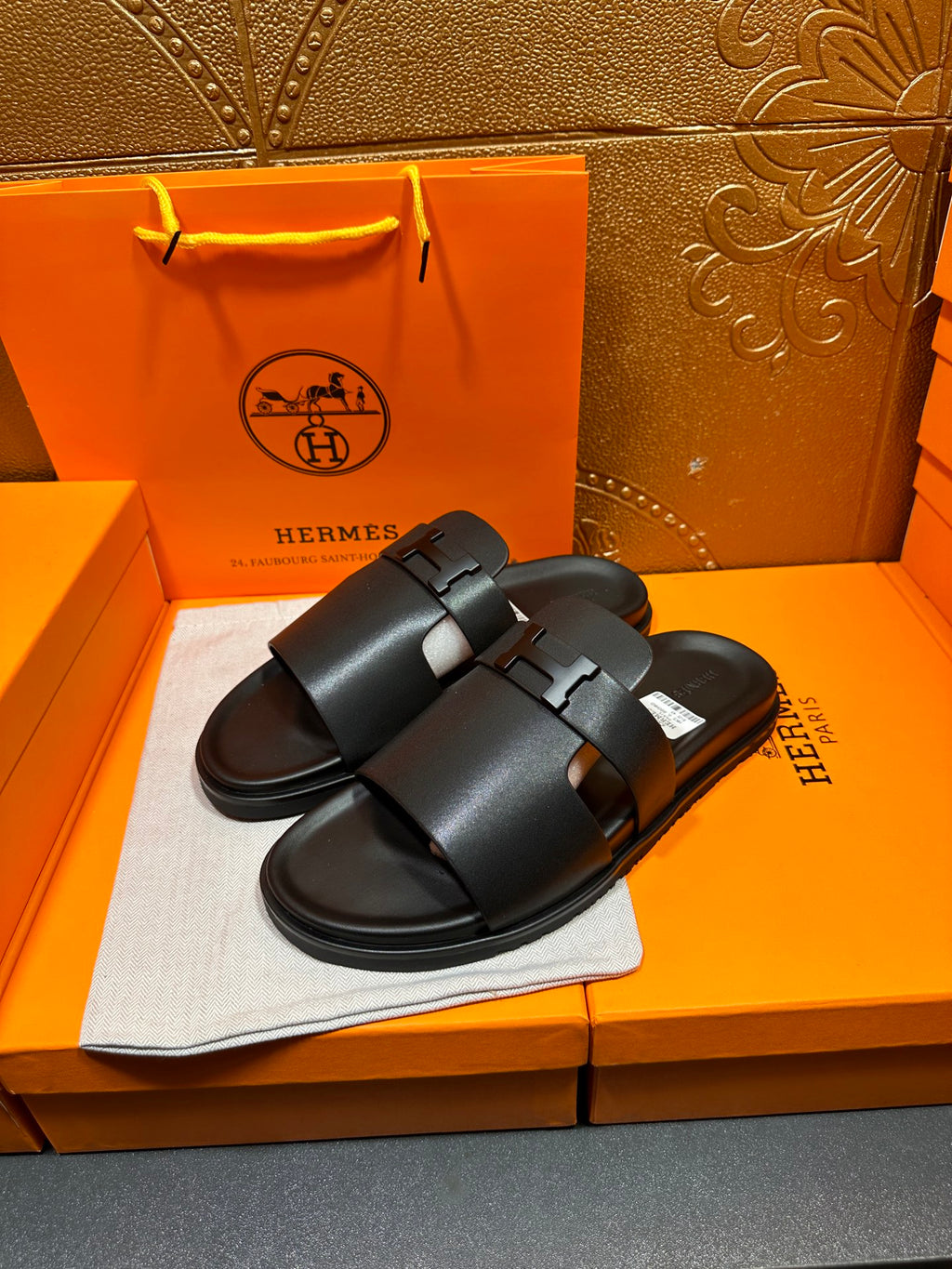 Black leather slide sandals with two wide straps and adjustable buckle, side view