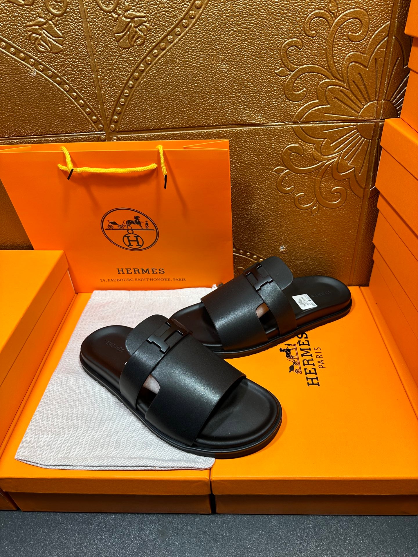 Black leather slide sandals with wide straps, low profile sole, adjustable buckle