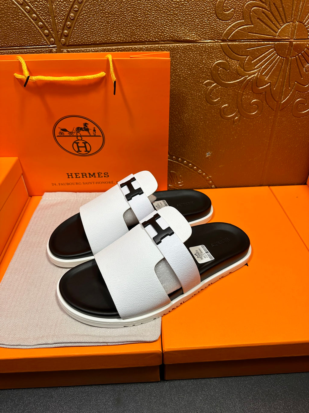 Hermes slide sandals, side view, white straps and black rubber soles