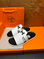 Hermes slide sandals, side view, white straps and black rubber soles
