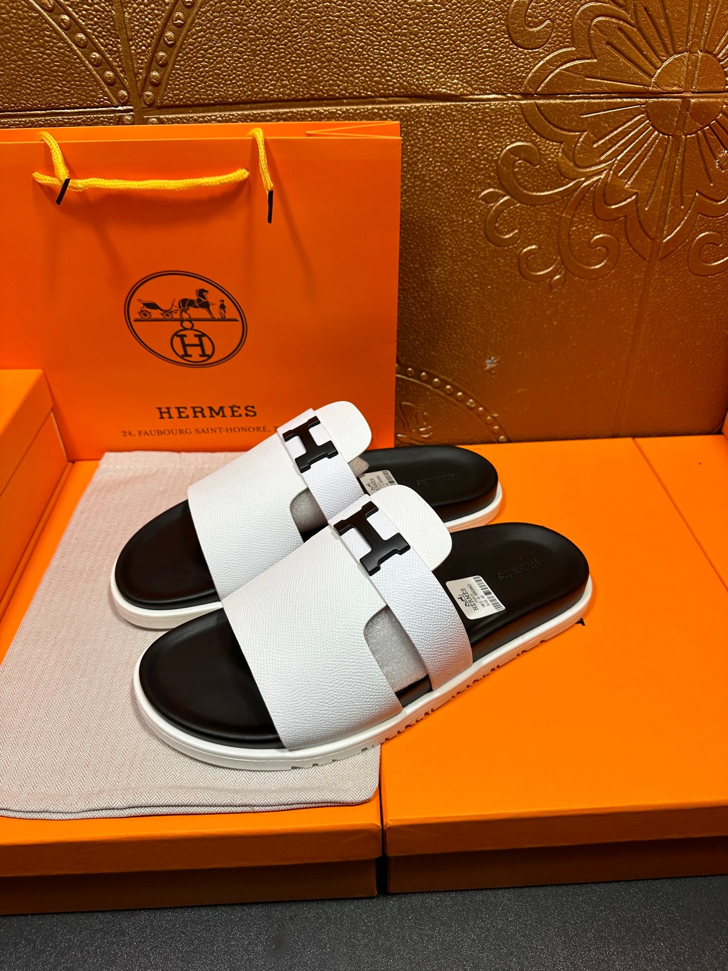 Hermes slide sandals, side view, white straps and black rubber soles