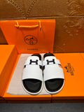 Hermes slide sandals with white straps, black soles, H buckle detail