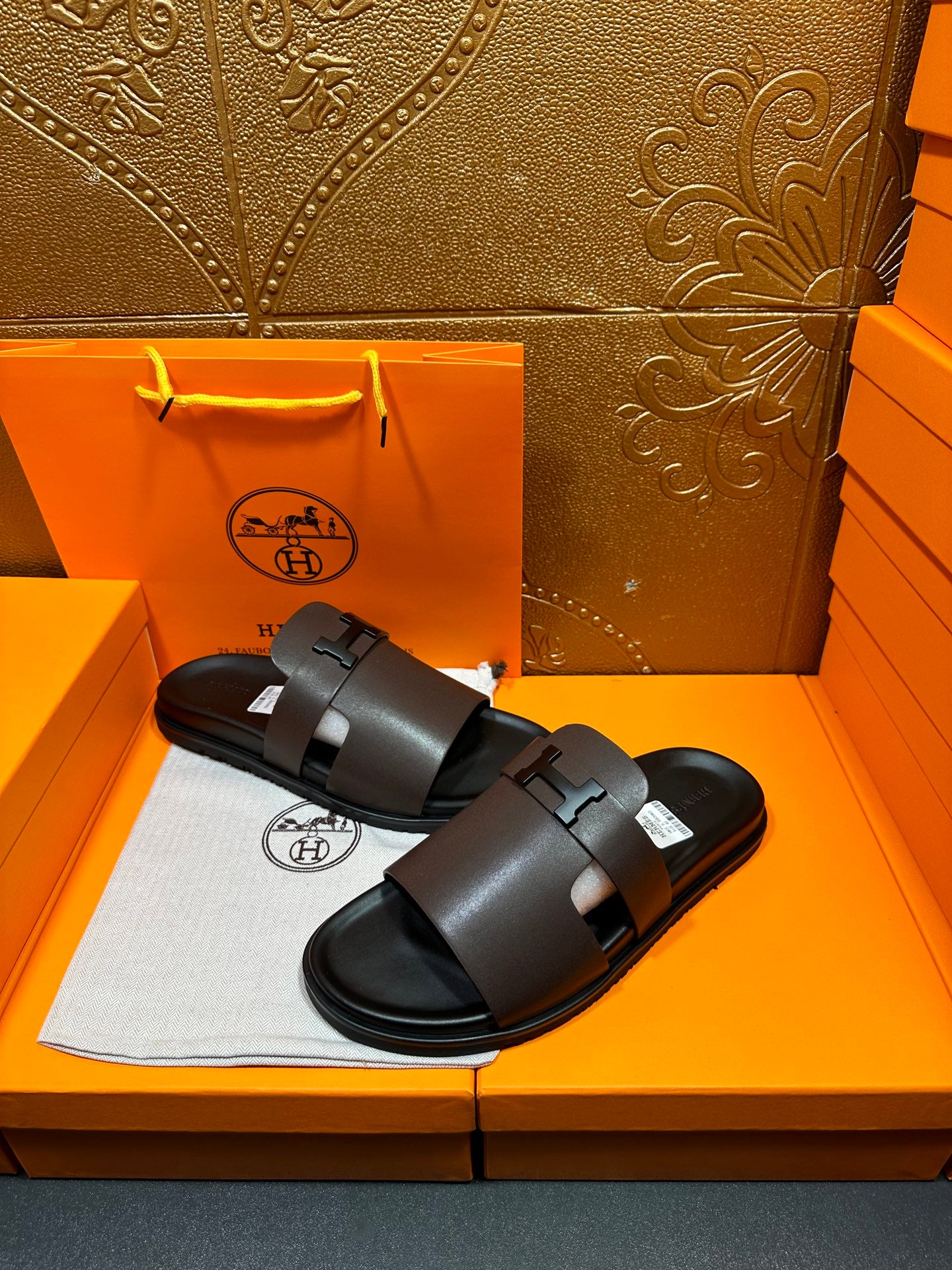 Dark leather slide sandal with wide front strap and buckle, open toe.