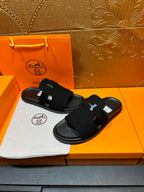 Hermes black slide sandals with H buckle straps, pair view