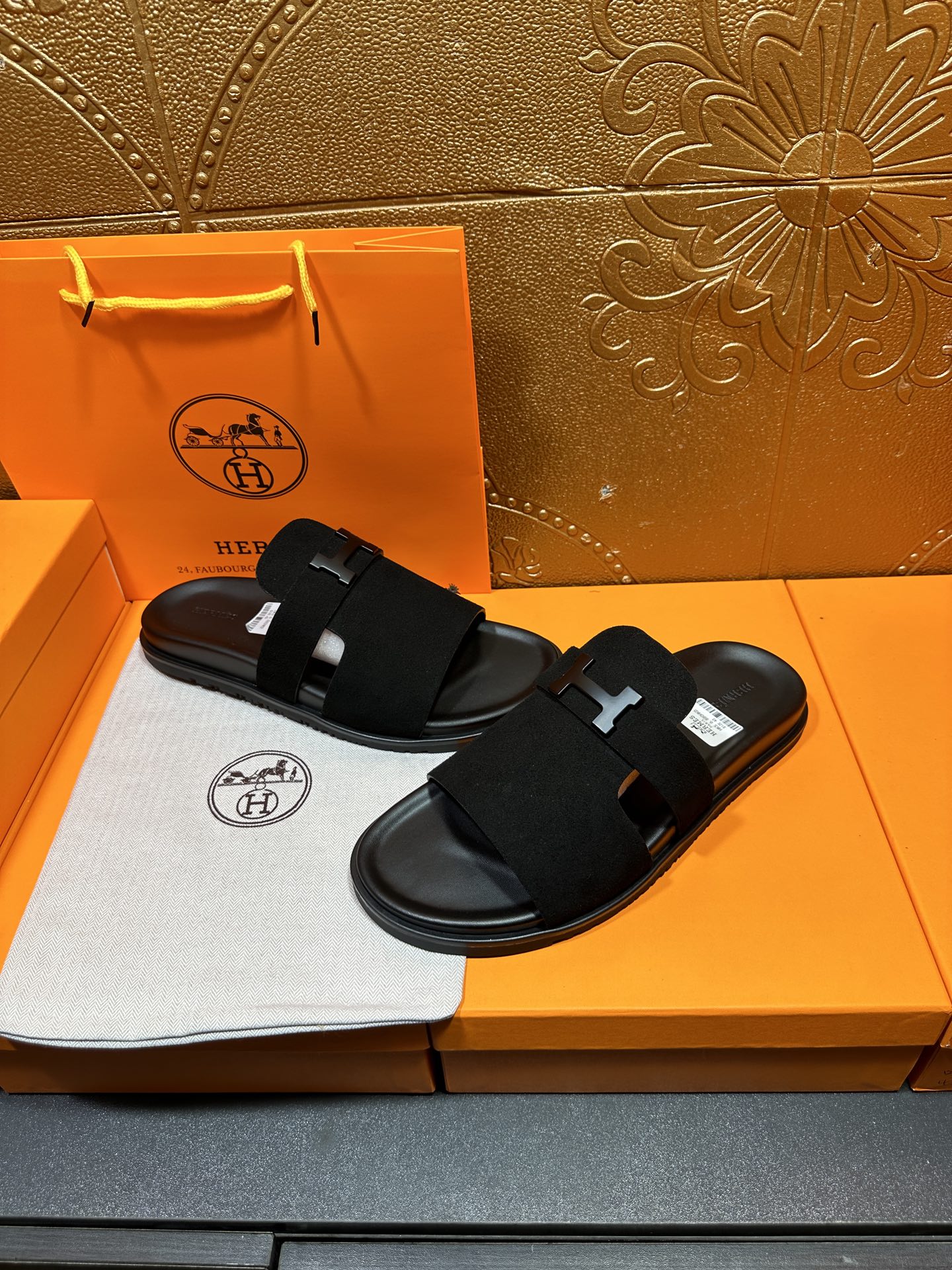 Hermes black slide sandals with H buckle straps, pair view