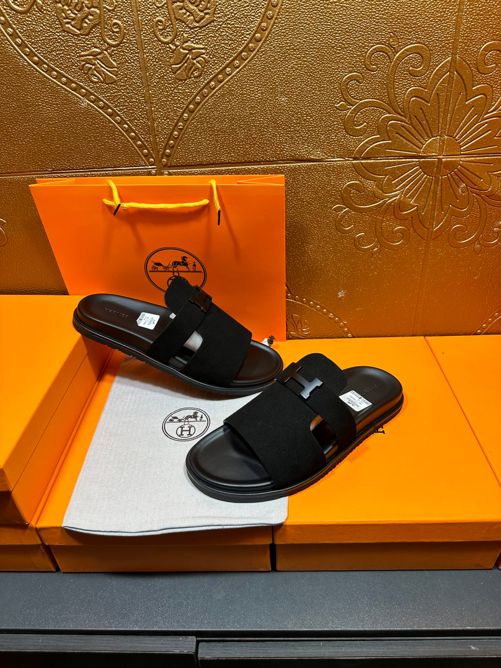 Hermes black slide sandals with H buckle straps, flat lay