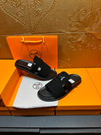 Hermes black slide sandals with H buckle straps, flat lay