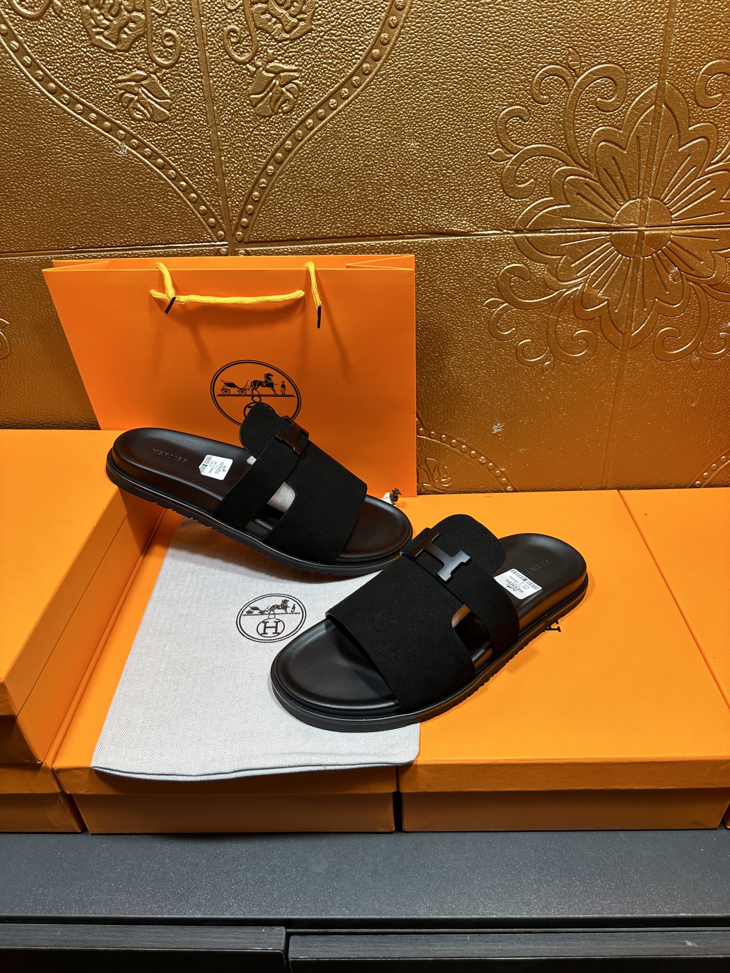 Hermes black slide sandals with H buckle straps, flat lay