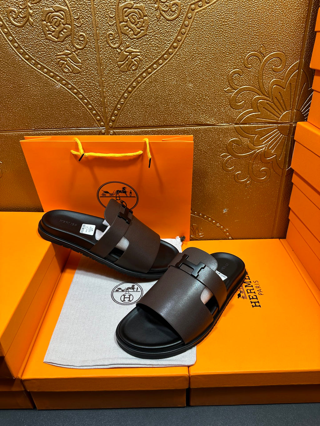 Dark leather slide sandals, wide buckle strap on front, open toe.