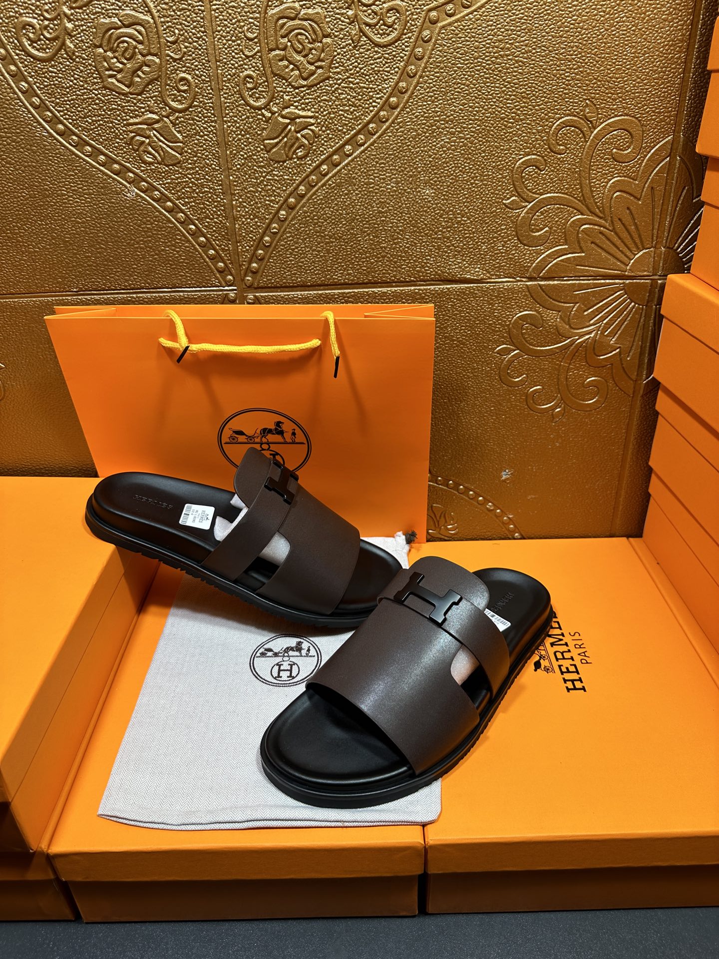 Dark leather slide sandals, wide buckle strap on front, open toe.