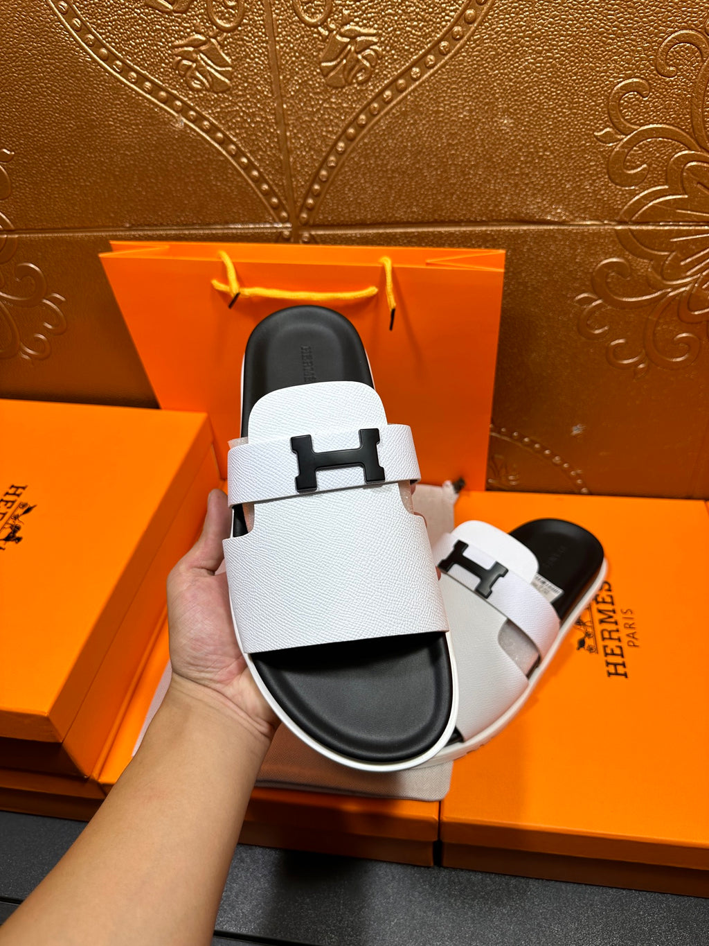Hermes slide sandals, white straps and black soles with H buckle close-up