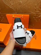 Hermes slide sandals, white straps and black soles with H buckle close-up