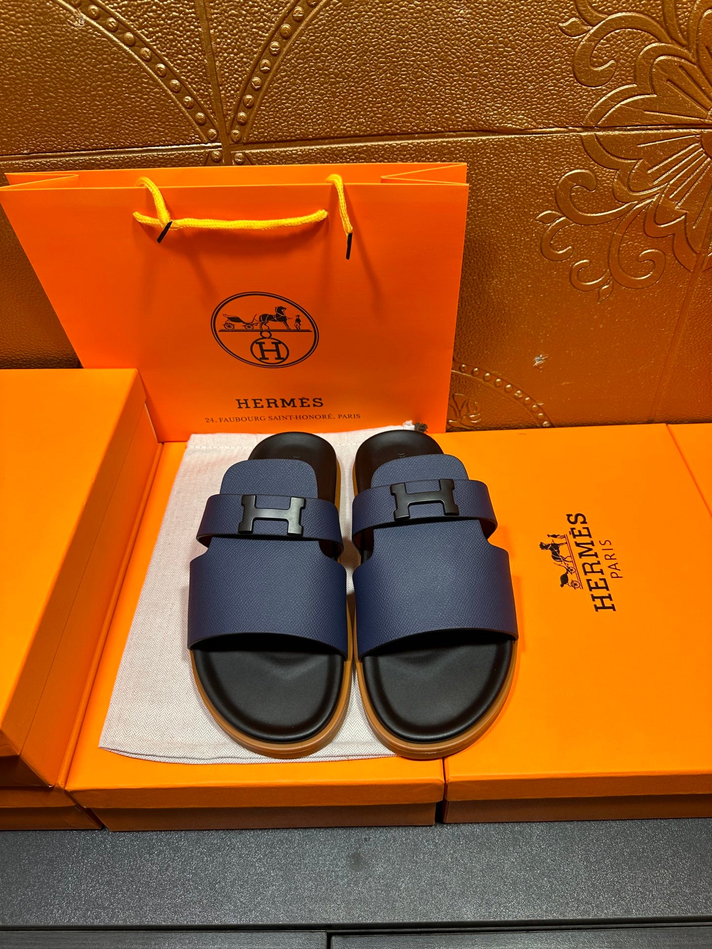 Dark blue leather slide sandals with squared buckle strap and black rubber sole