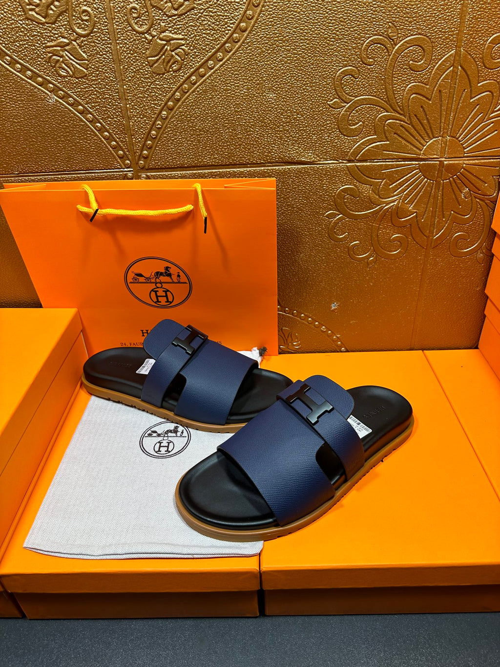 Blue leather slide sandals with adjustable buckle strap and black rubber outsole