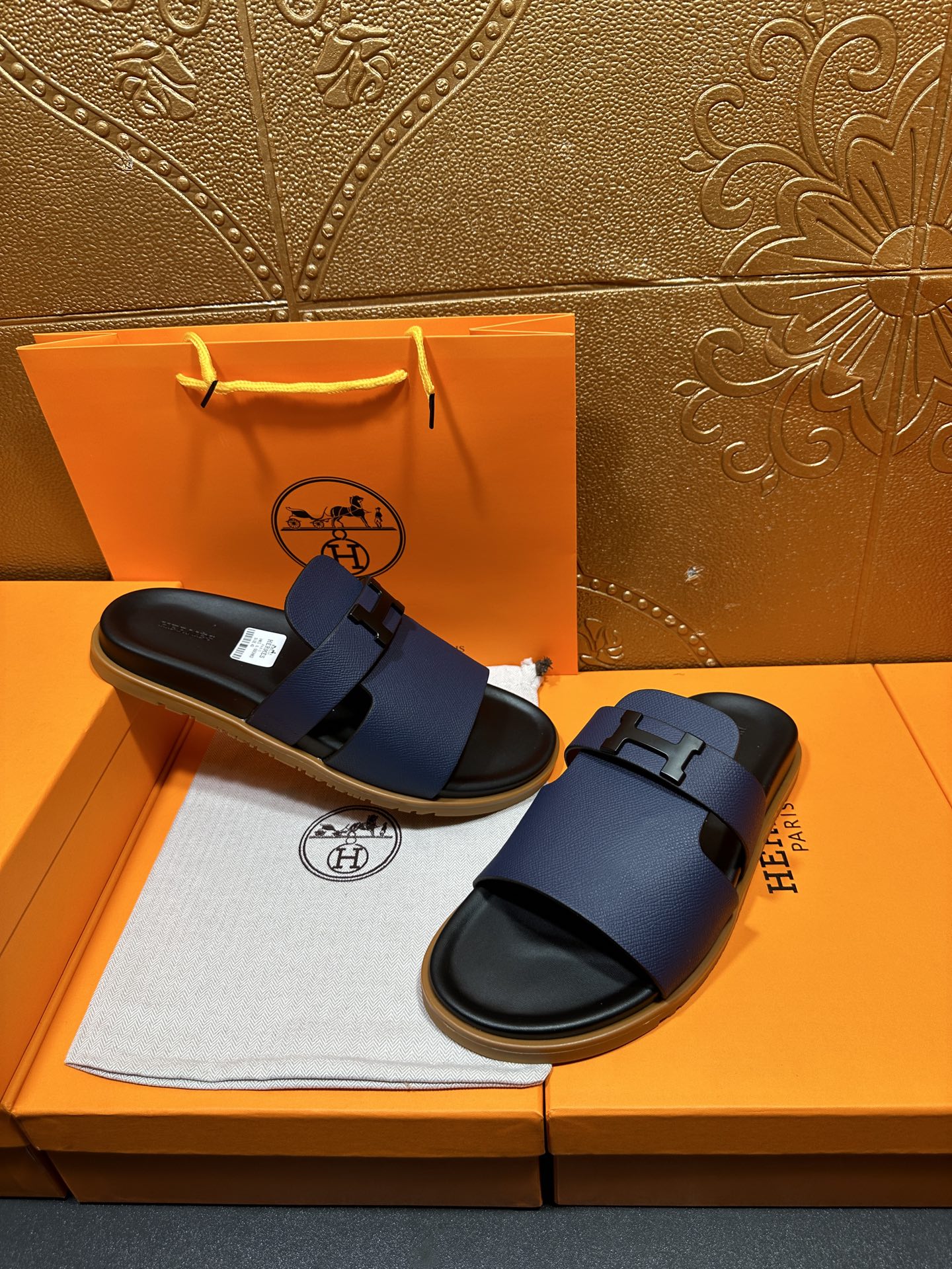 Dark blue leather slide sandals with buckle strap and black sole, shown together