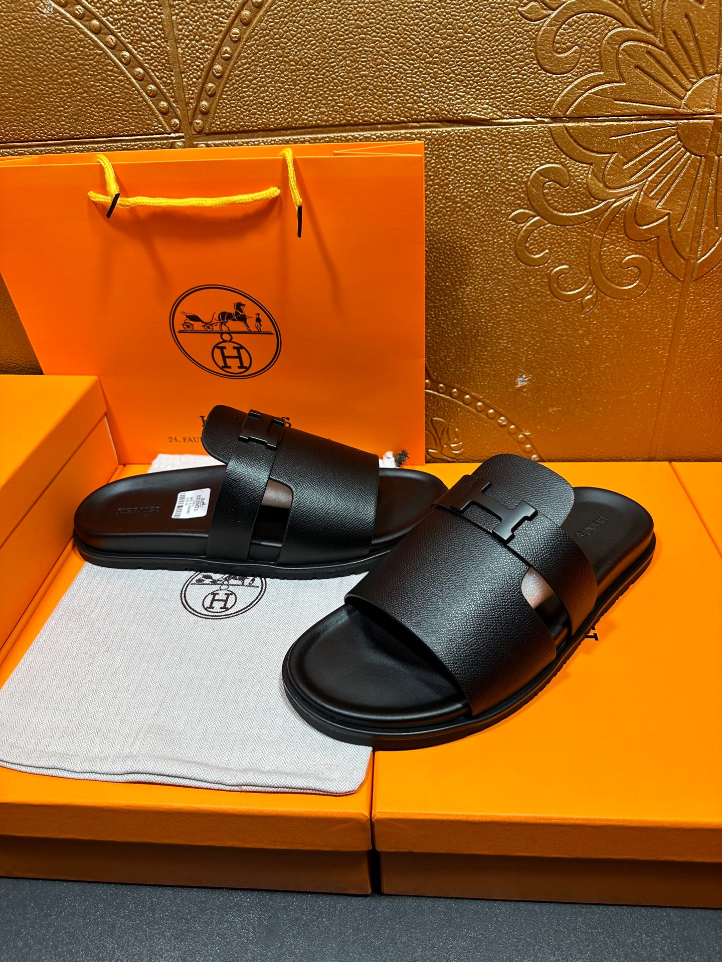 Pair of black leather slide sandals with double straps and buckle closures.