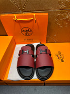Hermes slide sandals with burgundy leather straps and silver H buckle, black footbed.