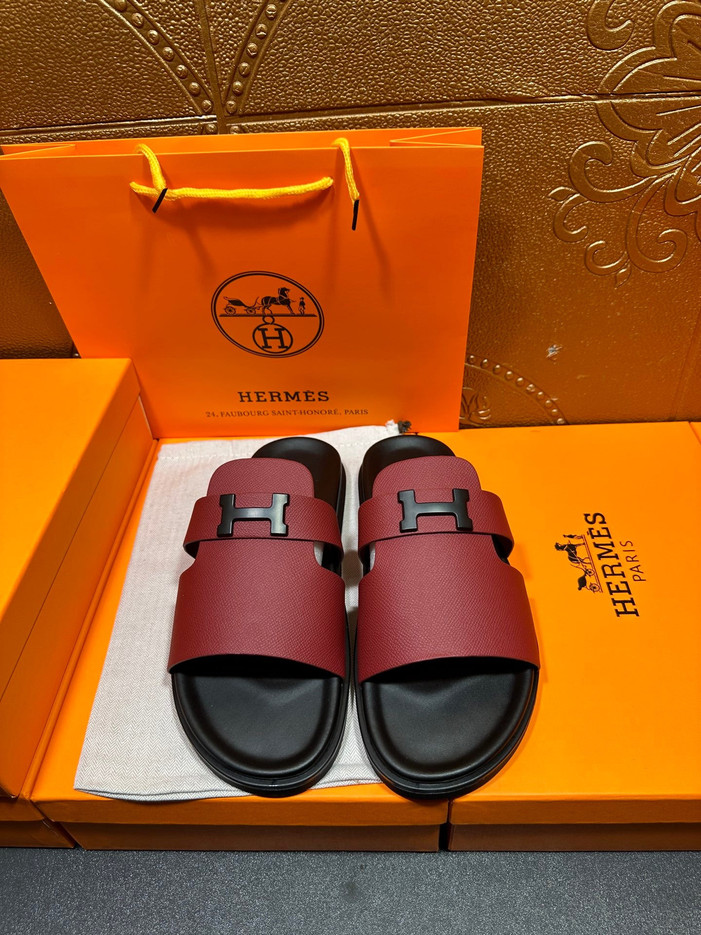 Hermes slide sandals with burgundy leather straps and silver H buckle, black footbed.