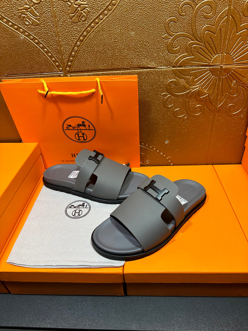 Dark gray slide sandals with square H buckle, open-toe flat sole