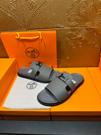 Dark gray slide sandals with square H buckle, open-toe flat sole