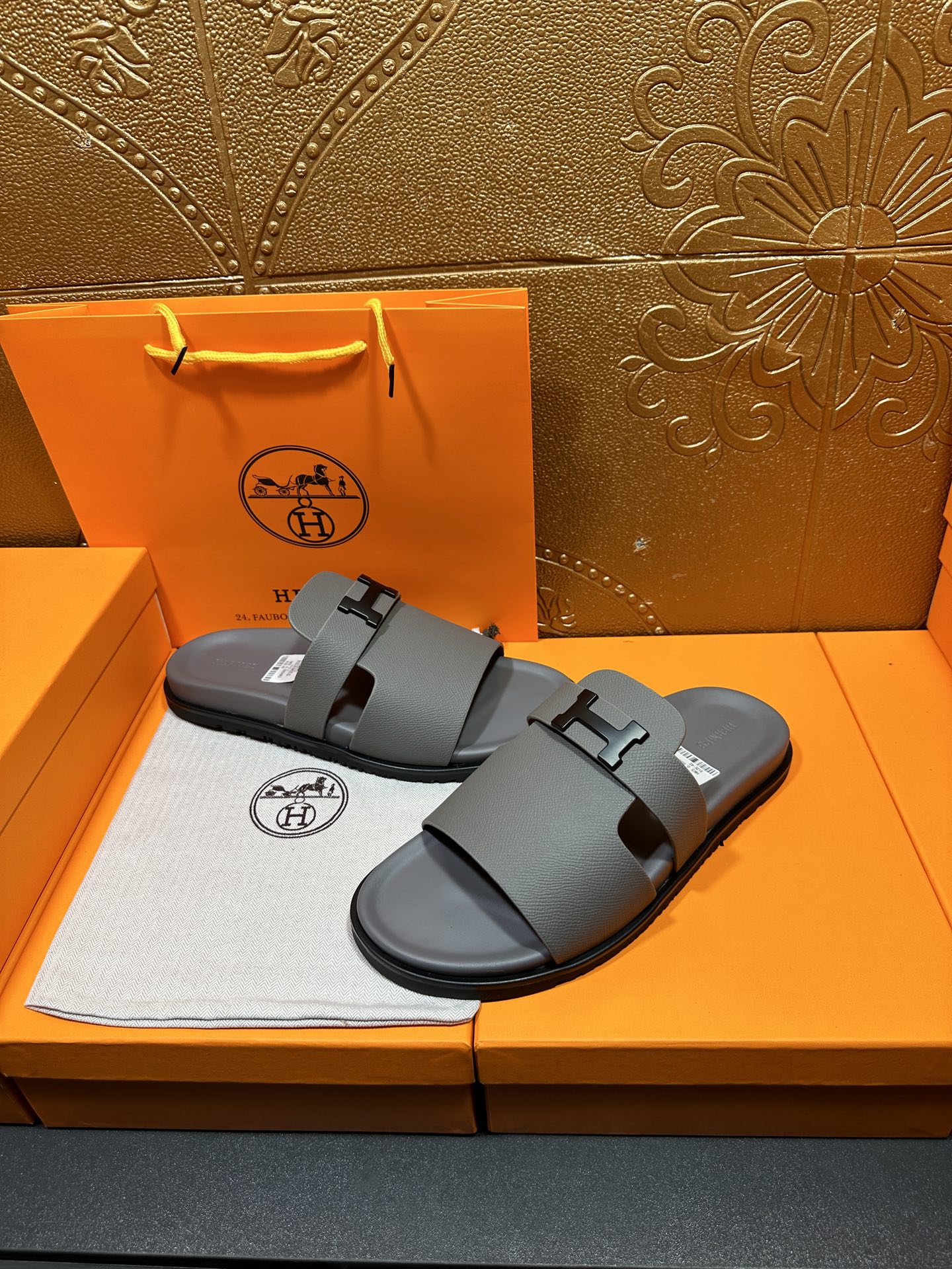 Dark gray slide sandals with square H buckle, open-toe flat sole
