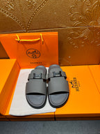 Dark gray slide sandals with square H buckle, front view on display