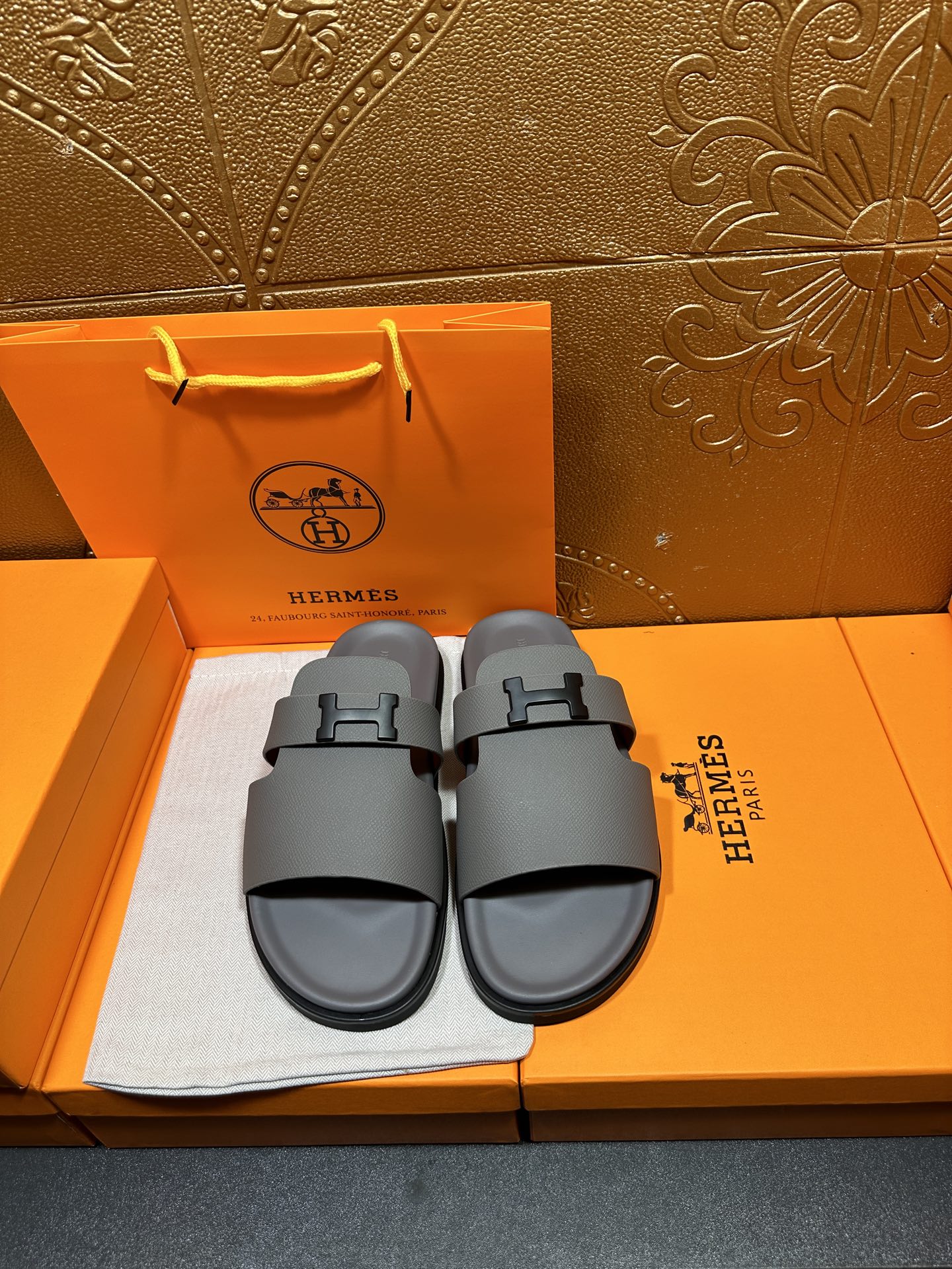 Dark gray slide sandals with square H buckle, front view on display