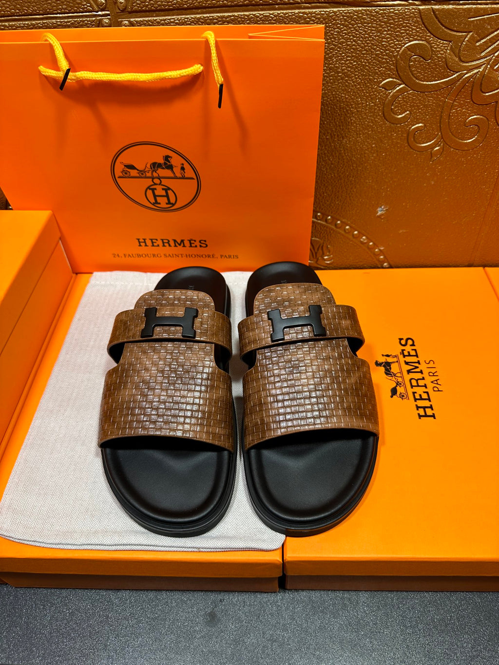 Hermes sandals with brown textured straps, black footbeds, metal H-style buckle