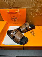 Hermes sandals with brown textured straps, black soles, metal buckle on each strap