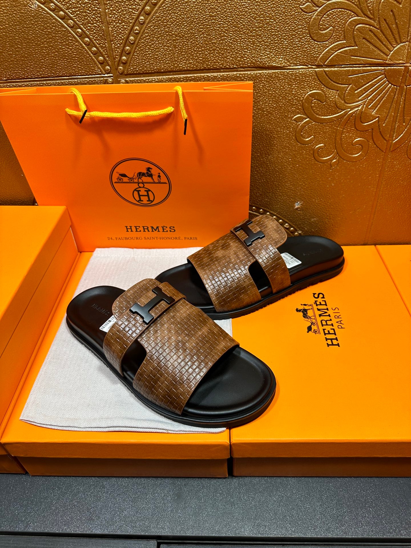 Hermes sandals with brown textured straps, black soles, metal buckle on each strap