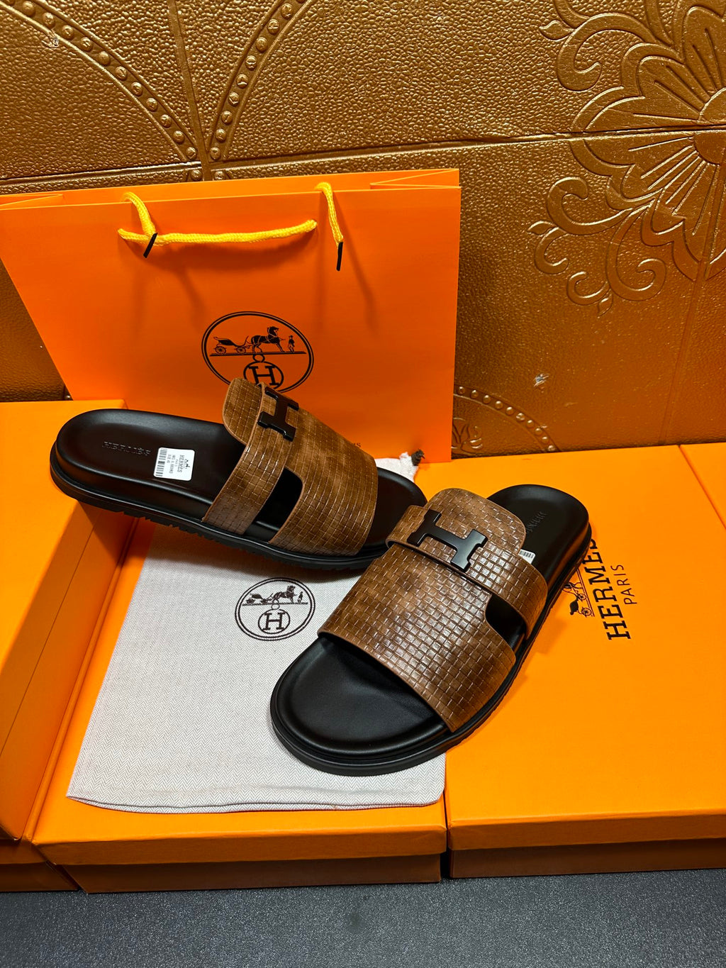 Hermes sandals with brown textured straps and black footbeds, metal buckle