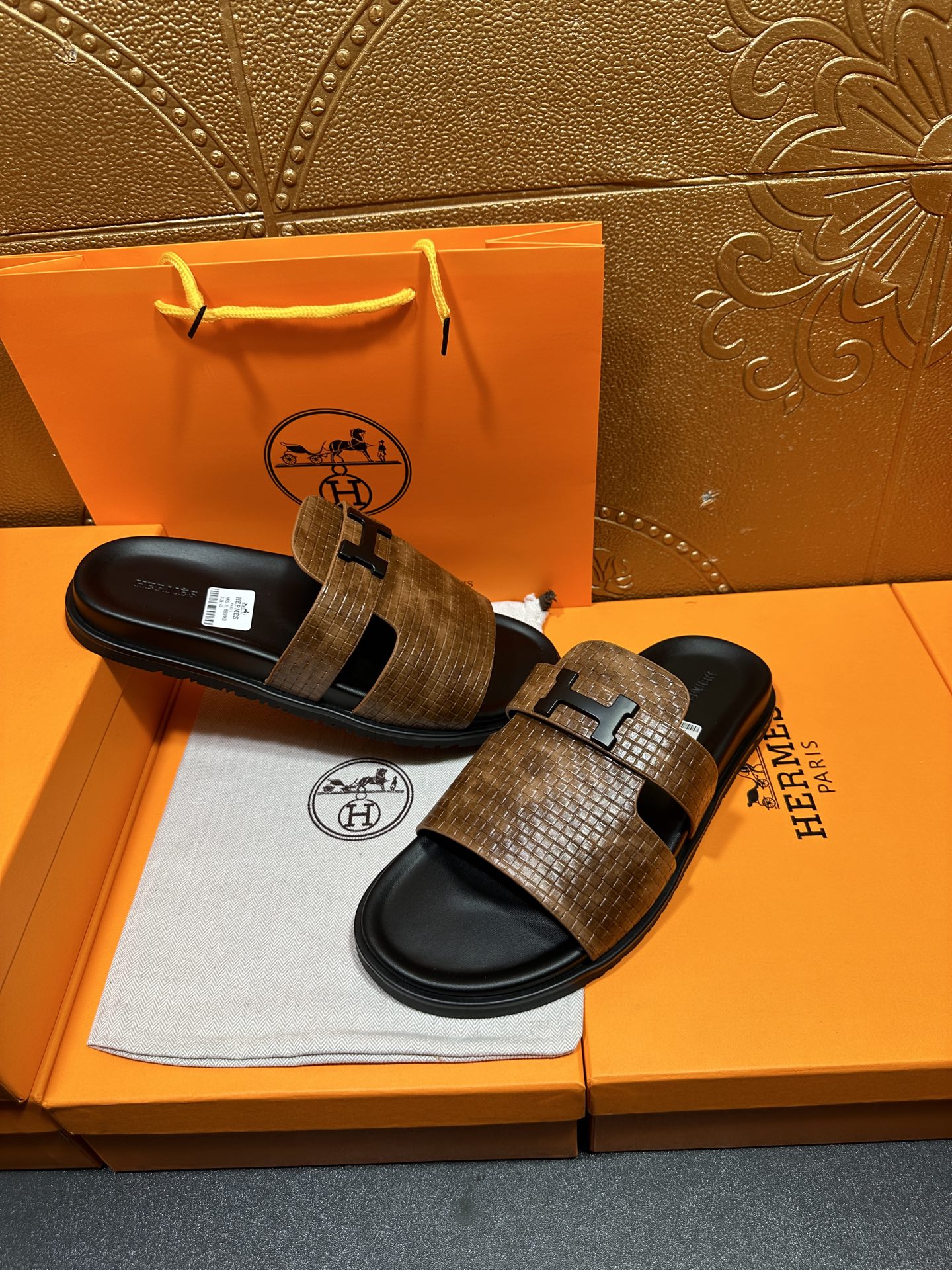Hermes sandals with brown textured straps and black footbeds, metal buckle