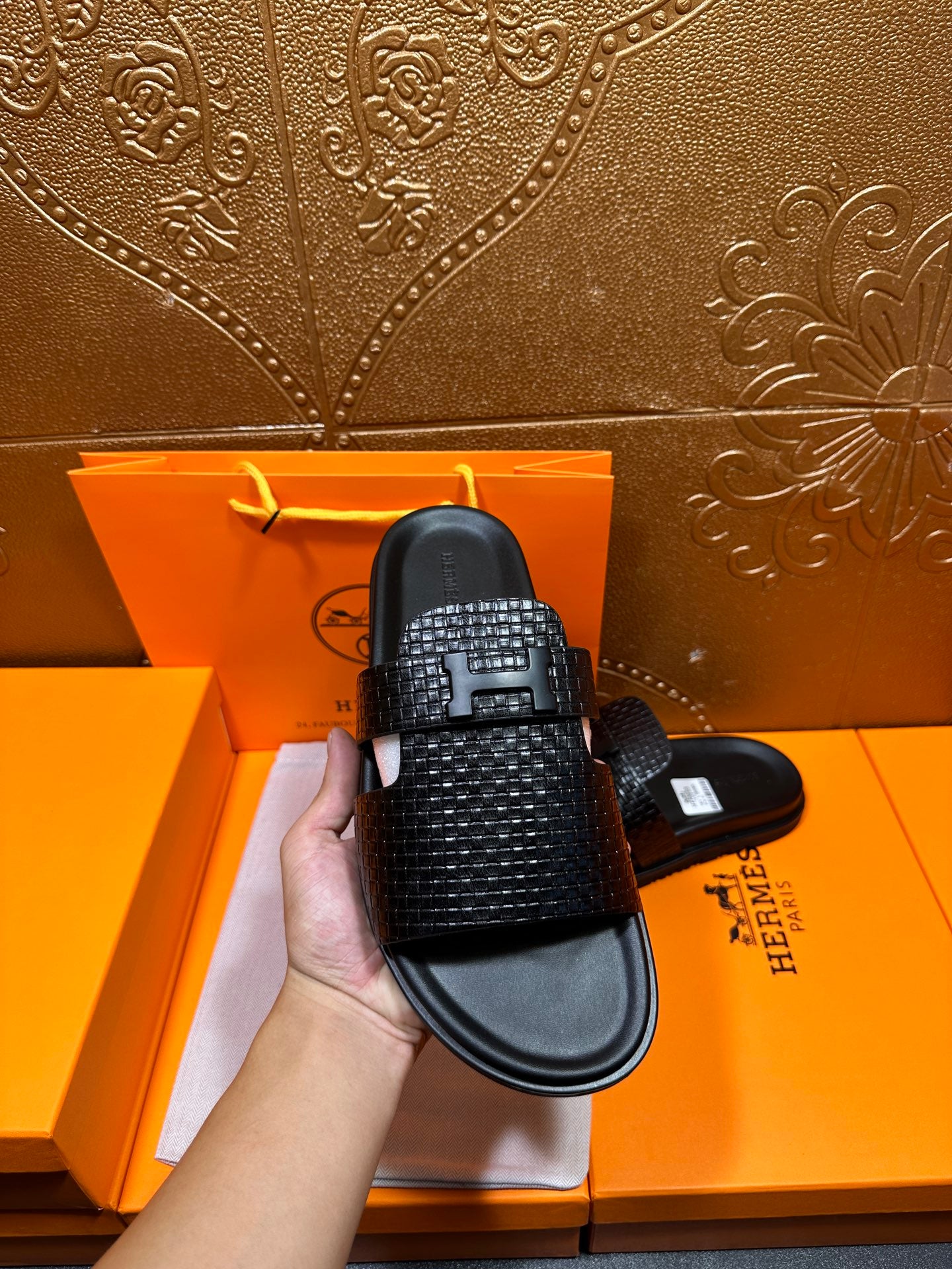Hermes black textured slide sandal close-up with wide strap and black rubber sole