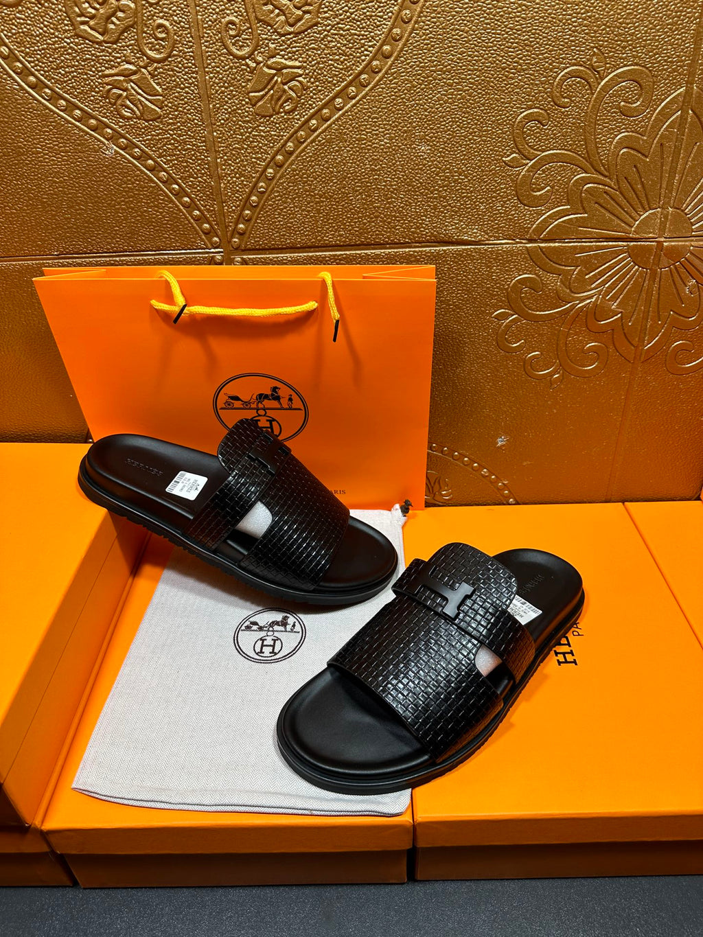 Hermes black textured slide sandals with wide crisscross straps and flat rubber base
