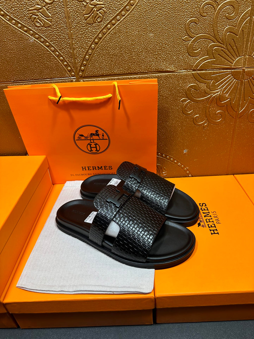 Hermes black textured slide sandals showing top strap detail and curved footbed