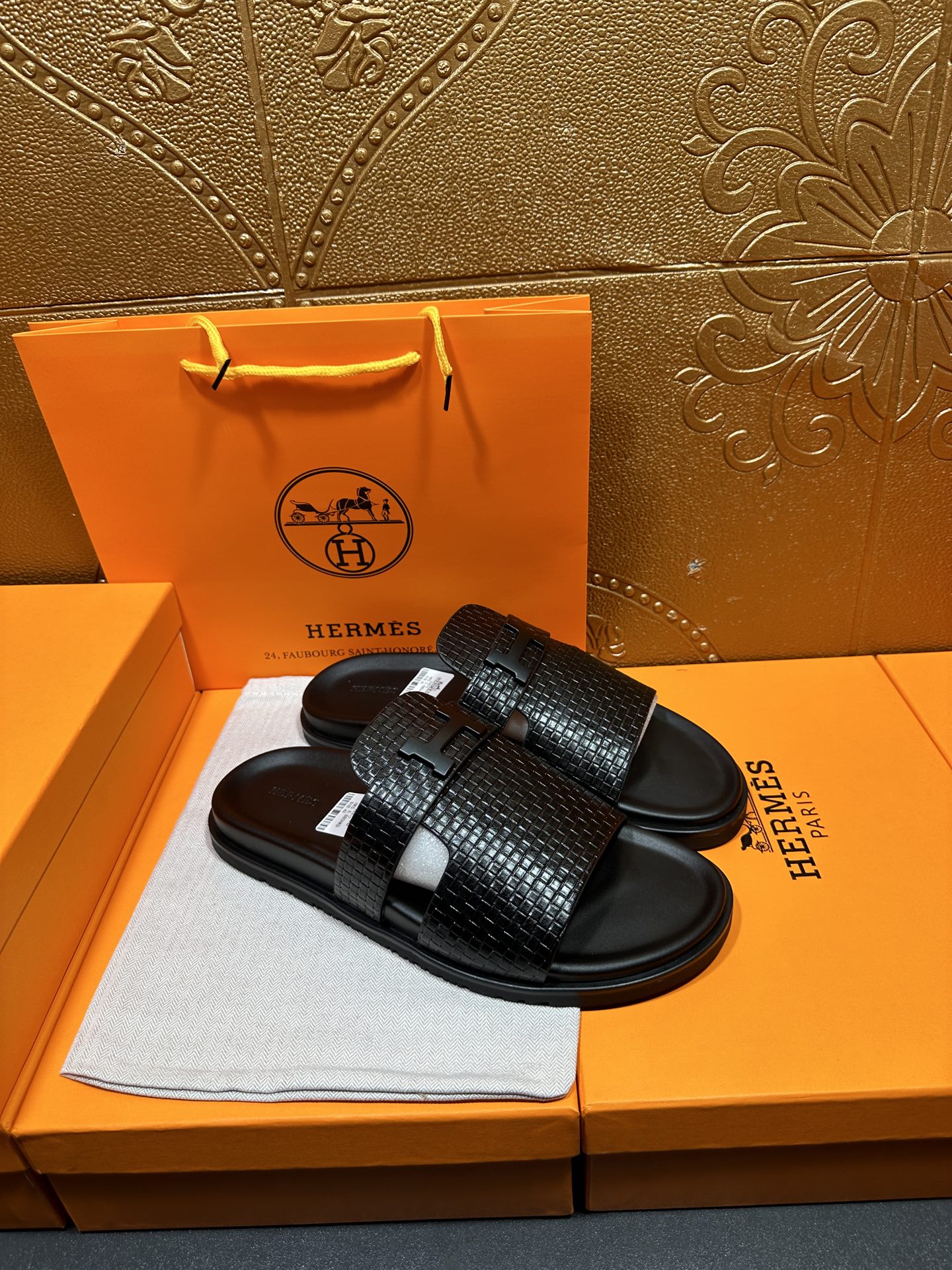 Hermes black textured slide sandals showing top strap detail and curved footbed