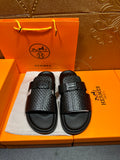 Hermes black textured slide sandals with wide cross-strap and black rubber footbed