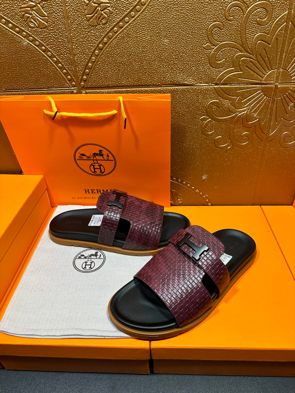 Hermes slide sandals, burgundy patterned strap bands and black buckle on dark slides