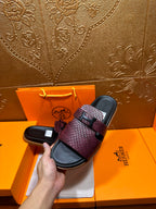 Hermes slide sandals held together, burgundy textured straps with black buckle and dark footbeds