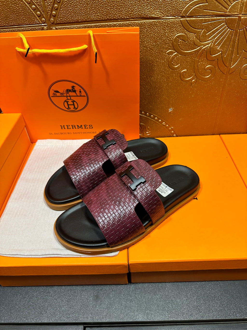 Hermes slide sandals pair, burgundy textured straps with black footbed and logo buckle